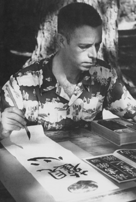 Alan Watts doing Chinese calligraphy, 1958. Photo by Ken Kay.